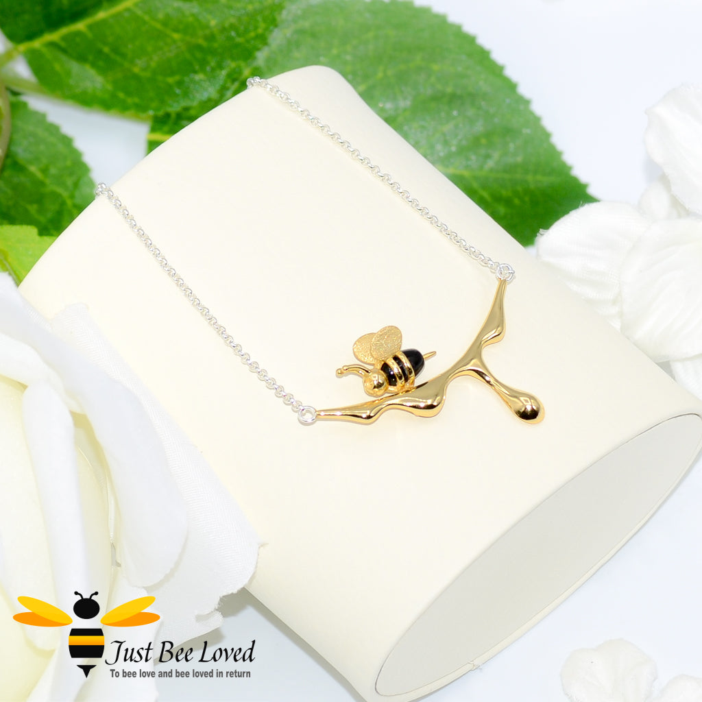 sterling silver necklace featuring an 18kt gold plated 3D honey bee resting upon golden dripping honey. 