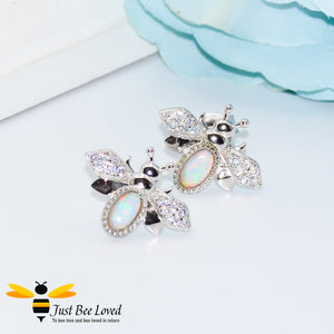 sterling silver bee stud earrings inlaid with colourful pale blue opal gemstones and white crystal encrusted wings.