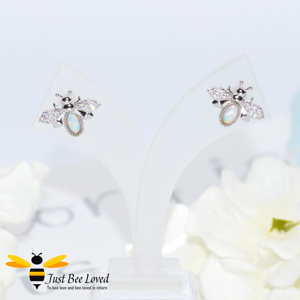 sterling silver bee stud earrings inlaid with colourful pale blue opal gemstones and white crystal encrusted wings.