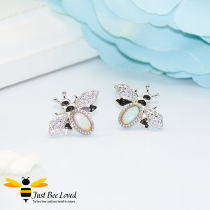 sterling silver bee stud earrings inlaid with colourful pale blue opal gemstones and white crystal encrusted wings.