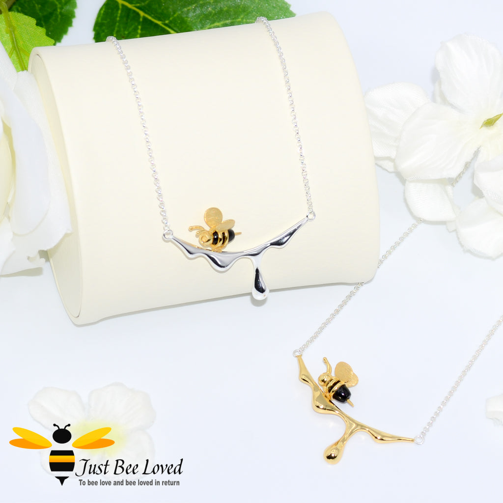 sterling silver necklaces featuring a design of an 18kt gold plated and black 3D honey bee resting upon dripping honey. 