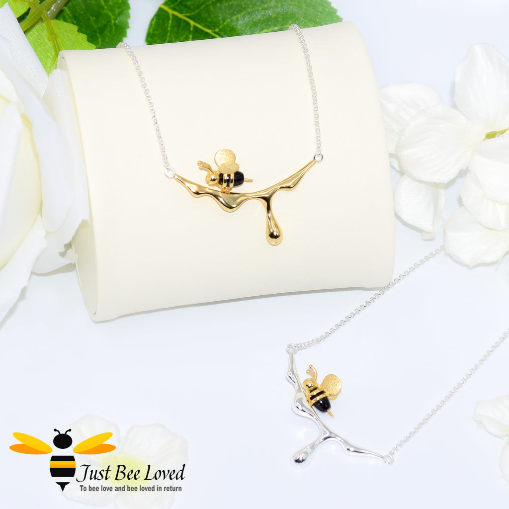sterling silver necklaces featuring a design of an 18kt gold plated and black 3D honey bee resting upon dripping honey. 