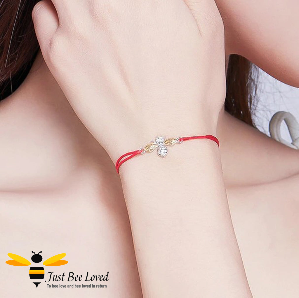 lady wearing a red friendship rope bracelet featuring an interlocked sterling silver bee with charm