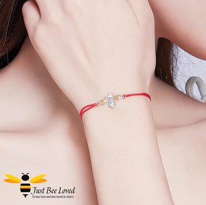 lady wearing a red friendship rope bracelet featuring an interlocked sterling silver bumblebee with 9kt gold plated wings and small SS star charm