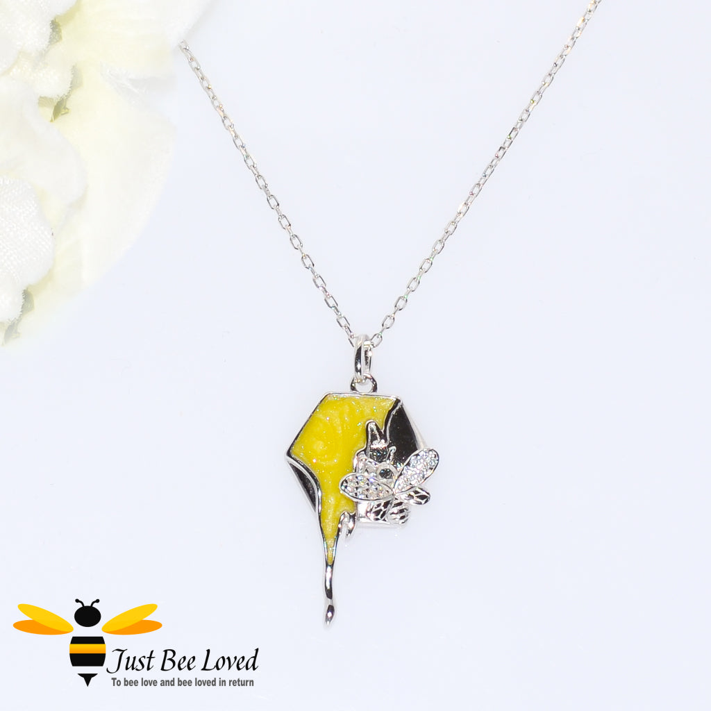 sterling silver necklace featuring a honeycomb shaped pendant with honey drip embellished with a silver bee