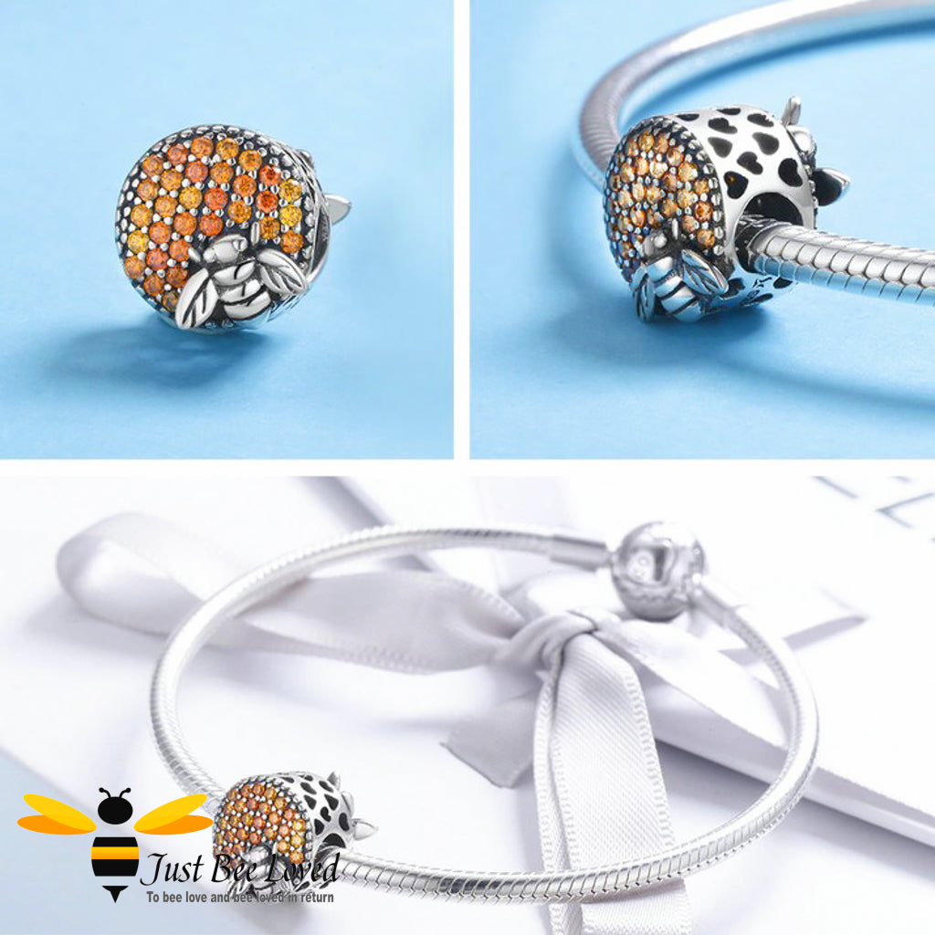 sterling silver charm detailing amber crystals with silver bees either side surrounded by hearts.