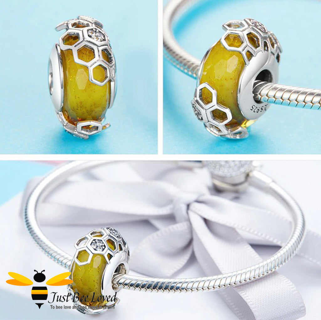 sterling silver charm detailing a honey coloured glass bead within a honeycomb casing paved with white cubic zirconia crystals