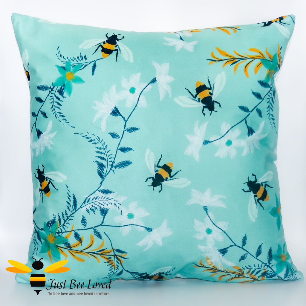 Teal coloured scatter cushion featuring an embroidery design of foraging bees and flowers.