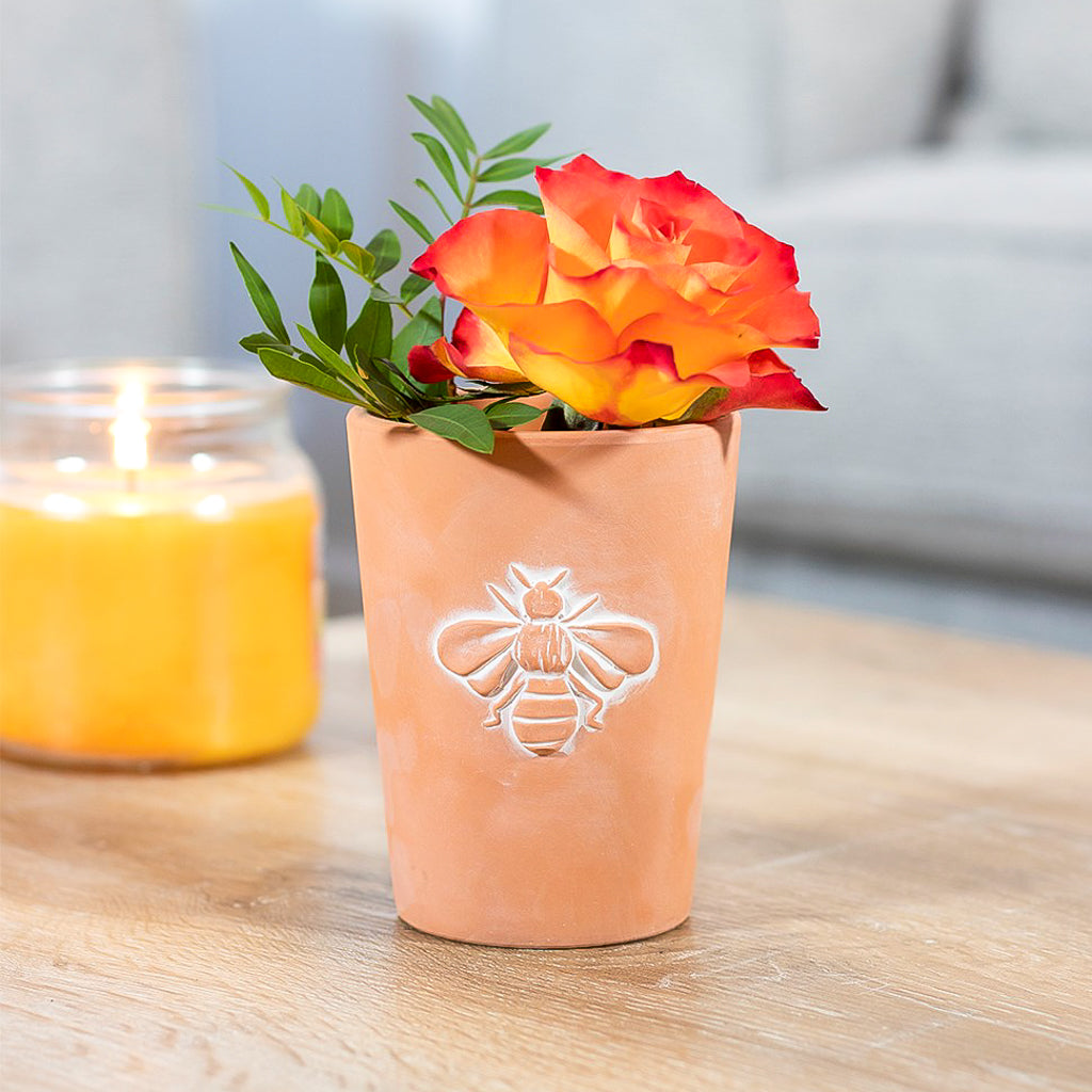 small rustic terracotta bee plant pot featuring a central embossed bee design