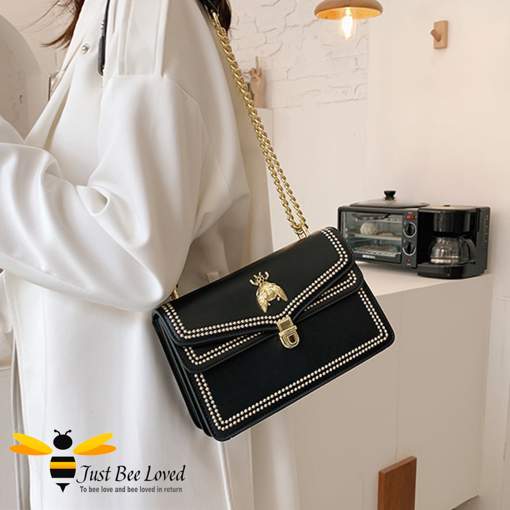 Black faux leather handbag with gold bee embellishment