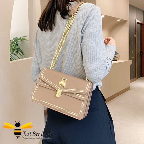 Taupe vegan leather handbag with embroidery edged stitching and large gold bee embellishment