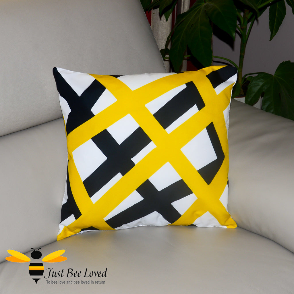 Contemporary scatter cushion featuring a black and yellow geometric criss cross design on a white background.
