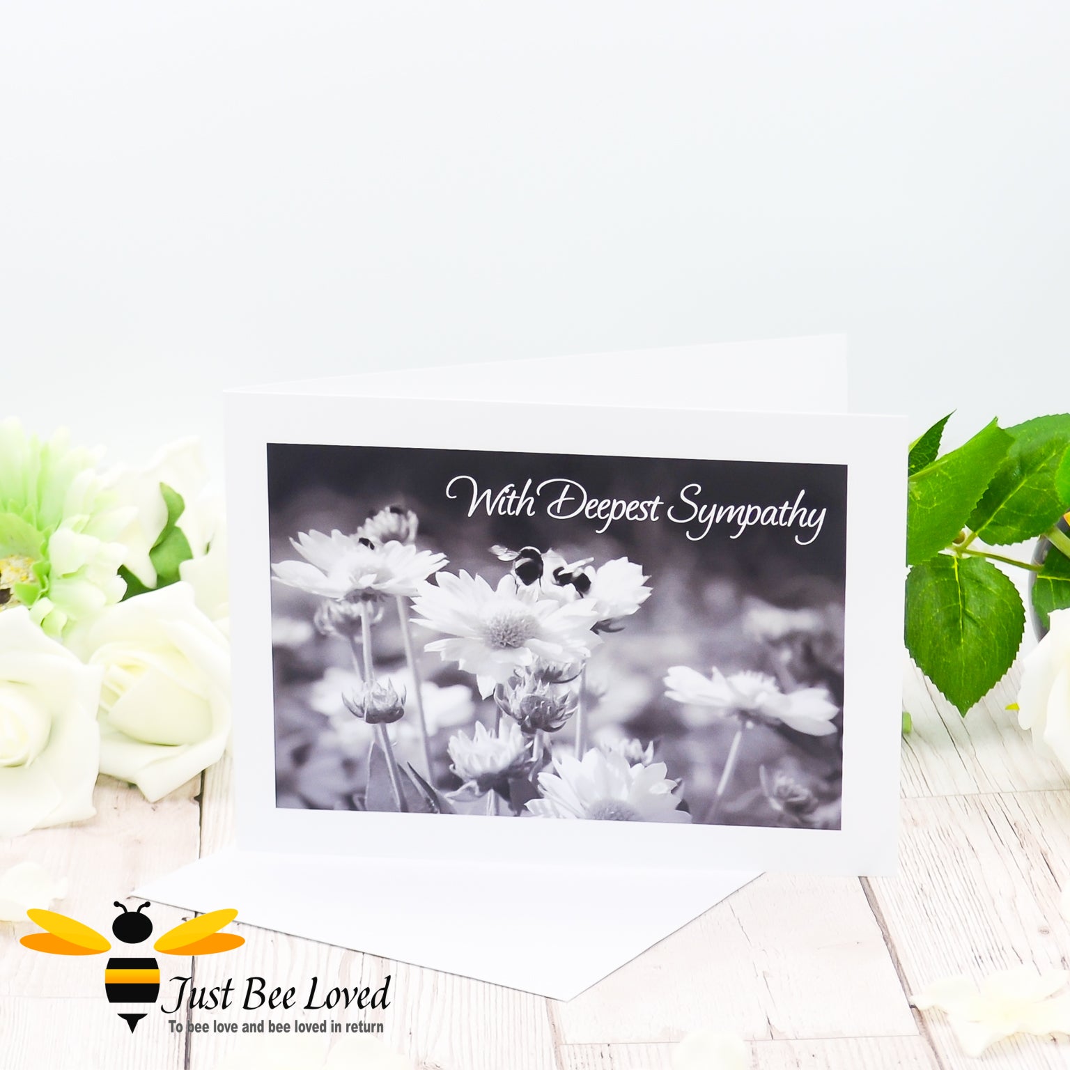 A photographic greeting card featuring a black and white image of bumblebees and daisies with the words 'With Deepest Sympathy'.