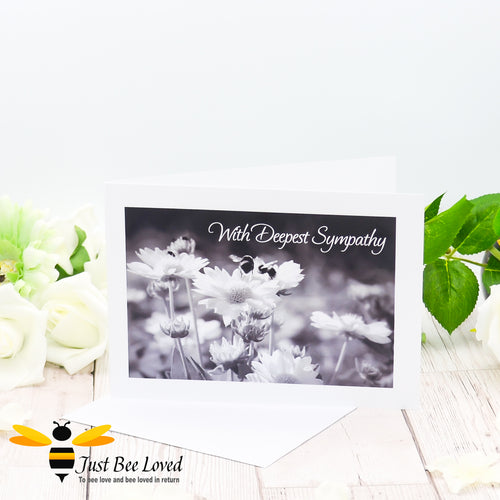 A photographic greeting card featuring a black and white image of bumblebees and daisies with the words 'With Deepest Sympathy'.