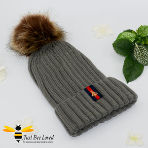 Grey ribbed knit hat featuring a faux fur pom pom with embroidered bumblebee tab on rim