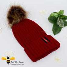 Load image into Gallery viewer, Wine ribbed knit hat featuring a faux fur pom pom with embroidered bumblebee tab on rim