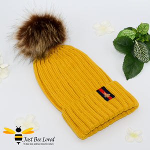 Yellow ribbed knit hat featuring a faux fur pom pom with embroidered bumblebee tab on rim