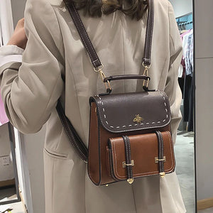 Woman wearing a brown vegan leather bumble bee backpack