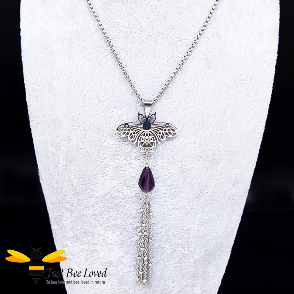 silver colour necklace with a bee pendant, purple crystal and tassel