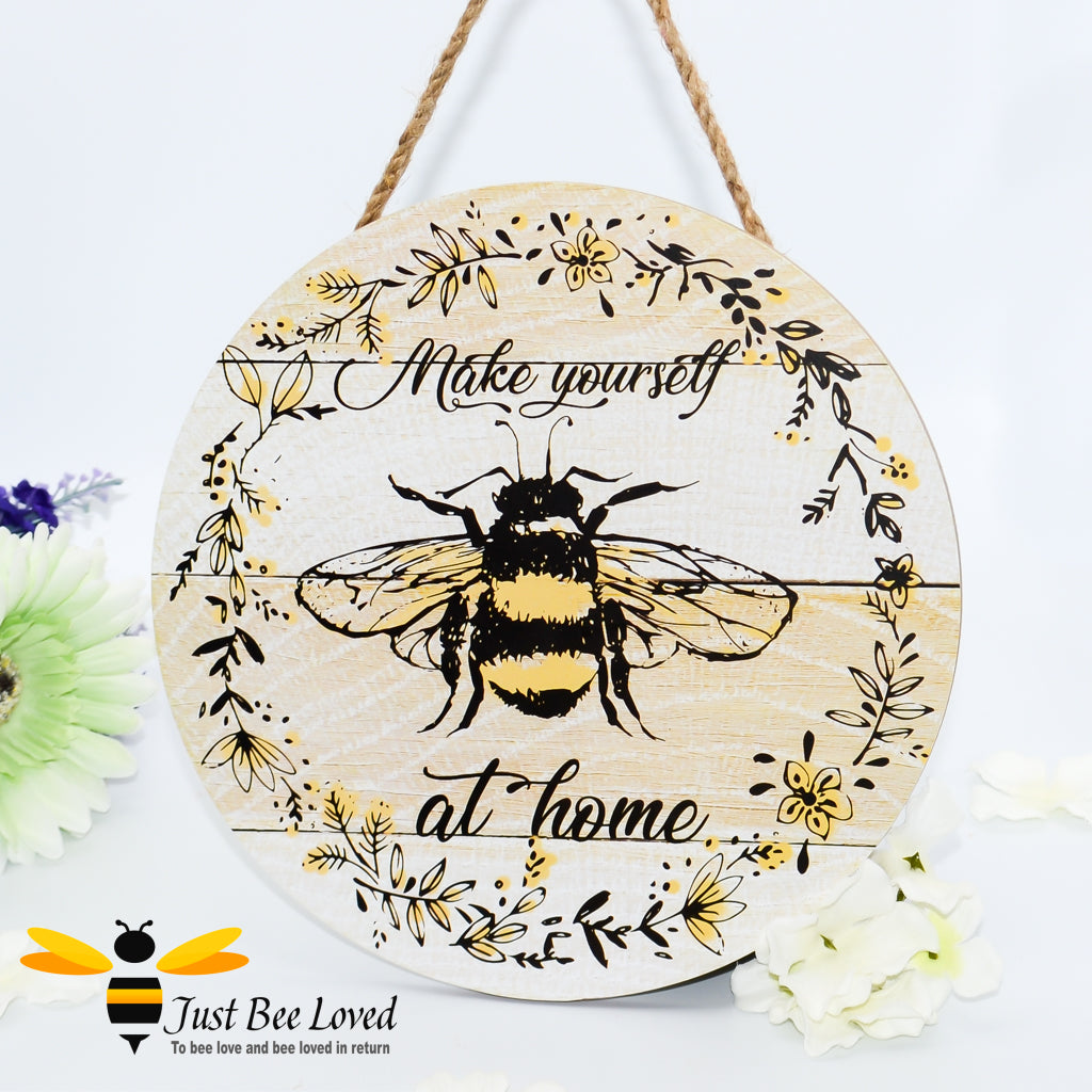 Round wooden hanging plaque with bumblebee illustration and 'make yourself at home' text.