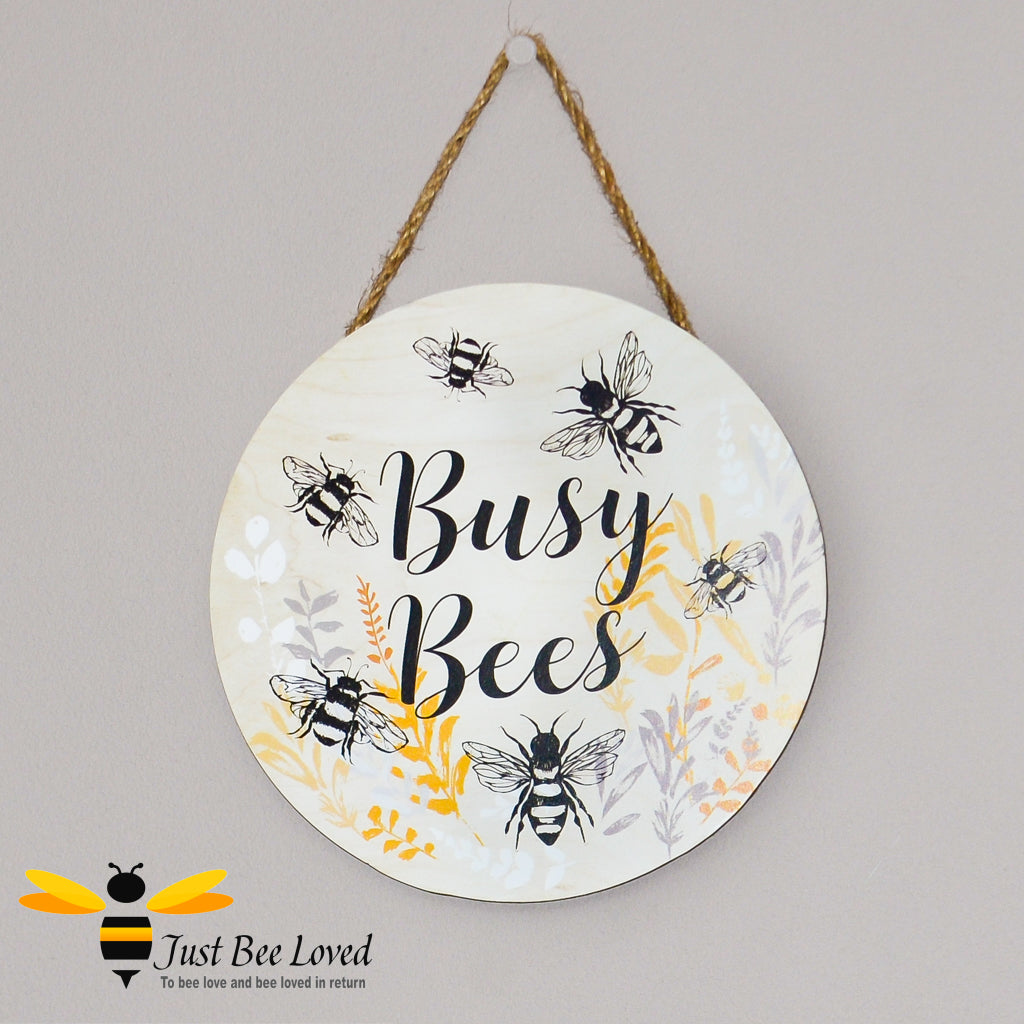 A wooden round hanging wall plaque with the text 'Busy Bees' and illustrations of bees.