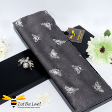 Load image into Gallery viewer, ladies scarf featuring metallic silver bumblebee print in dark grey, gift boxed with crystal bee brooch. 