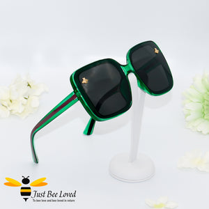 oversized retro styled square sunglasses featuring sweet gold bees on each lens in dark green colour