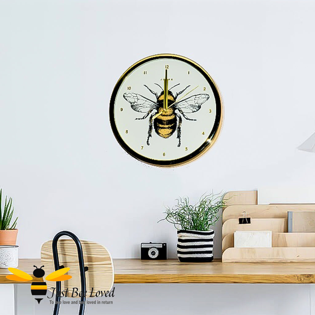 crafted round wall clock; designed with a gold rim casing and featuring a stunning bumblebee central print with gold Arabic dial and matching hands.