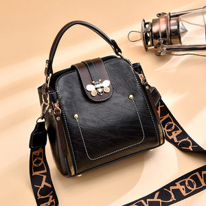 Flap over bumblebee two-toned vegan friendly leather handbag in black.