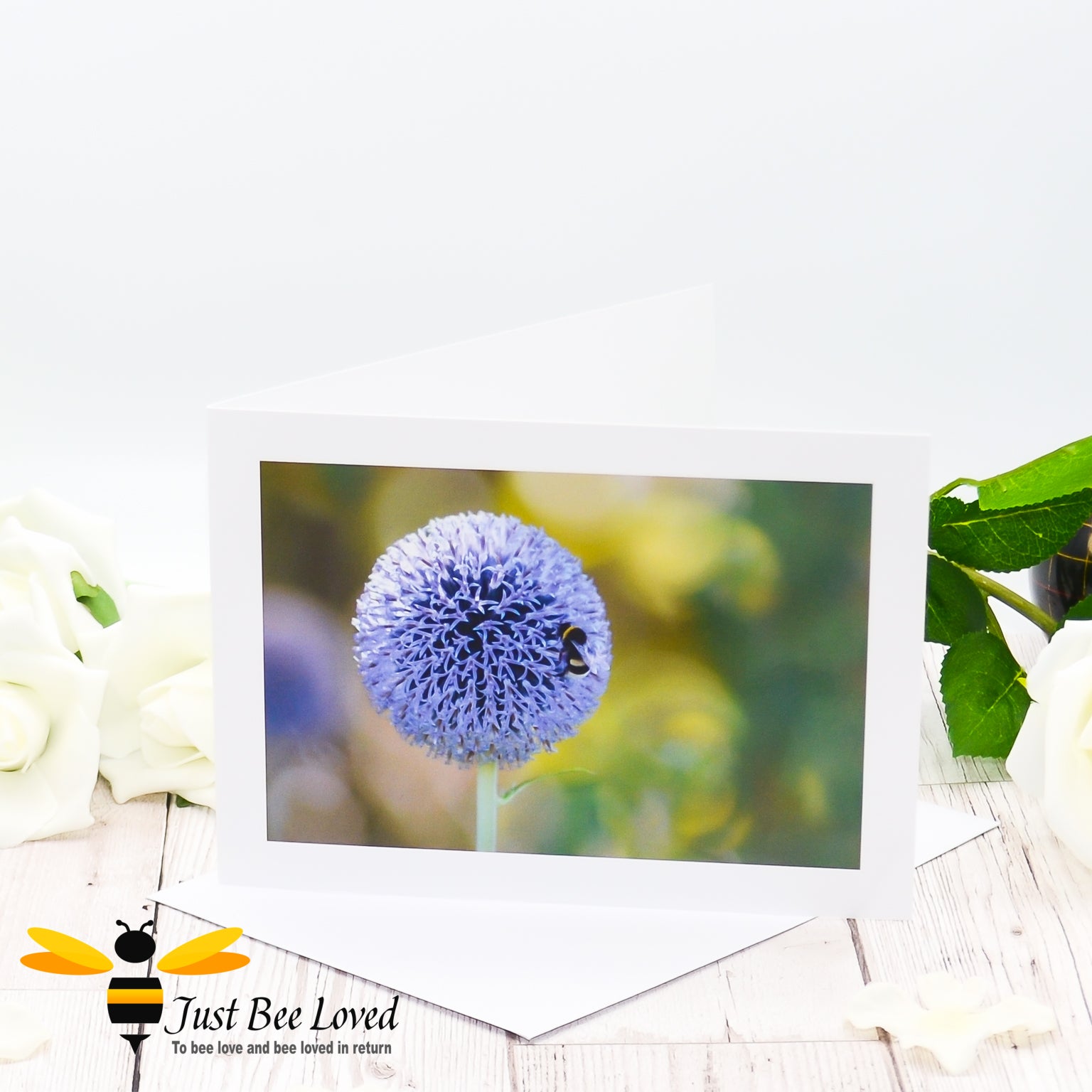 A photographic greeting card featuring an image of a white tailed bumblebee on a globe thistle flower.