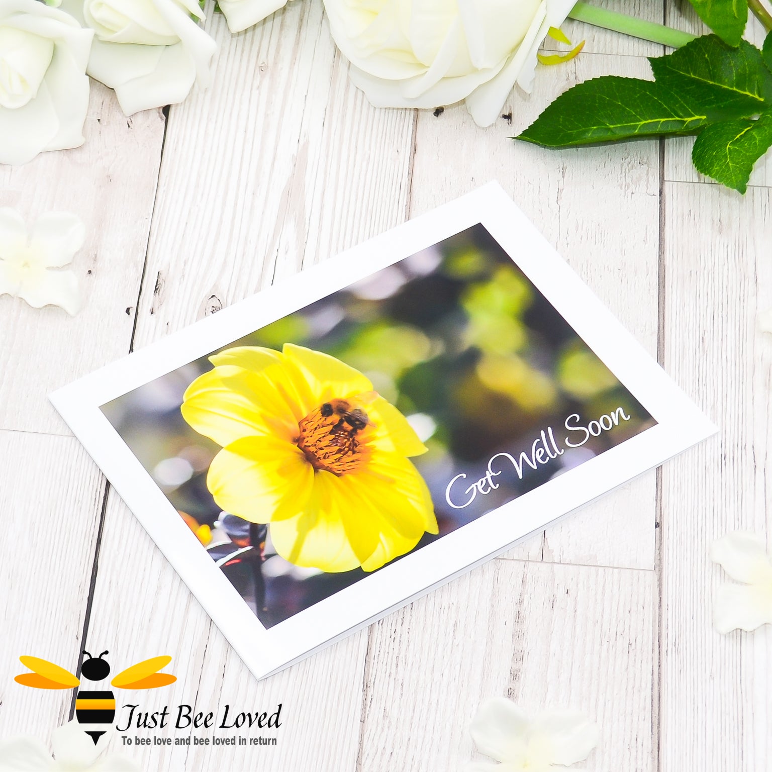 a photographic landscape print greeting card depicting a bumblebee foraging on a yellow dahlia flower with 'get well soon' text.