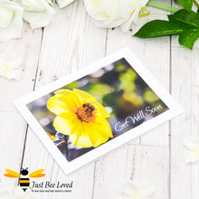 Load image into Gallery viewer, a photographic landscape print greeting card depicting a bumblebee foraging on a yellow dahlia flower with &#39;get well soon&#39; text.