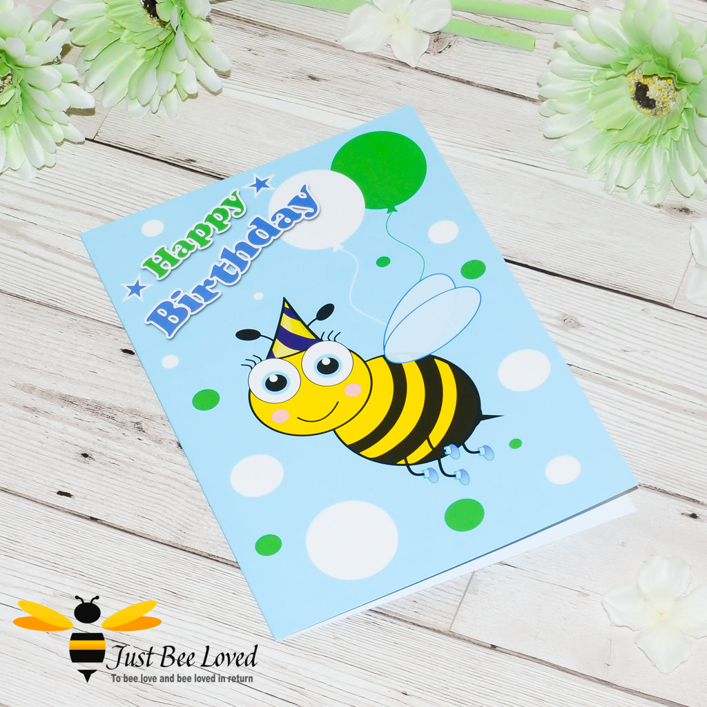 a birthday bee card featuring a cartoon illustration of a young bee wearing a blue party hat and holding colourful balloons.