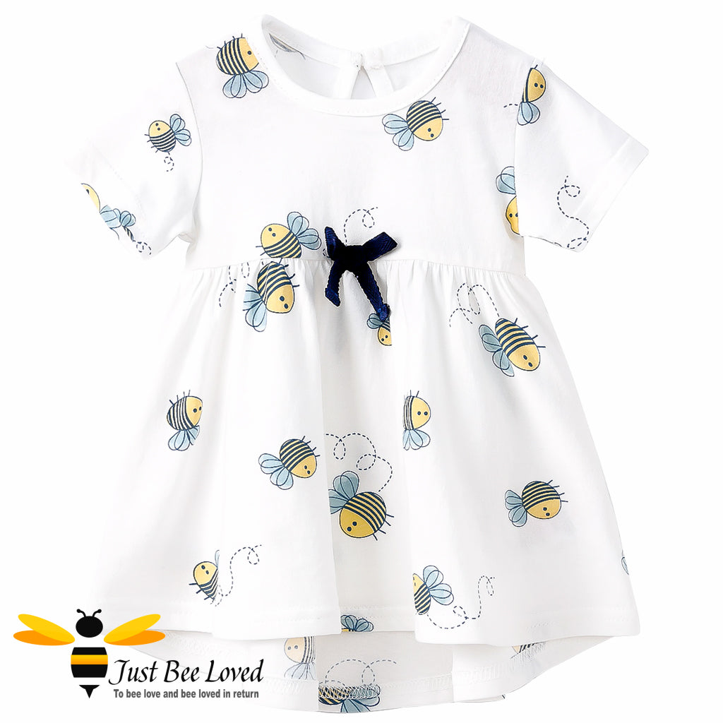 Baby girl white cotton summer swing dress featuring an all over pretty little bees print decorated with a coordinating navy bow.