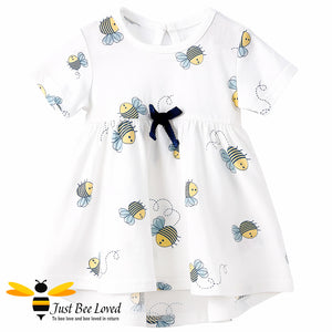 Baby girl white cotton summer swing dress featuring an all over pretty little bees print decorated with a coordinating navy bow.