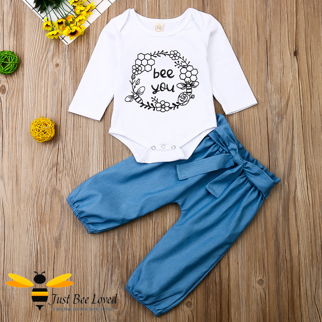 2-piece set featuring a white bodysuit with bees and flowers and the message "bee you" matched with coordinating harem styled blue pants.  