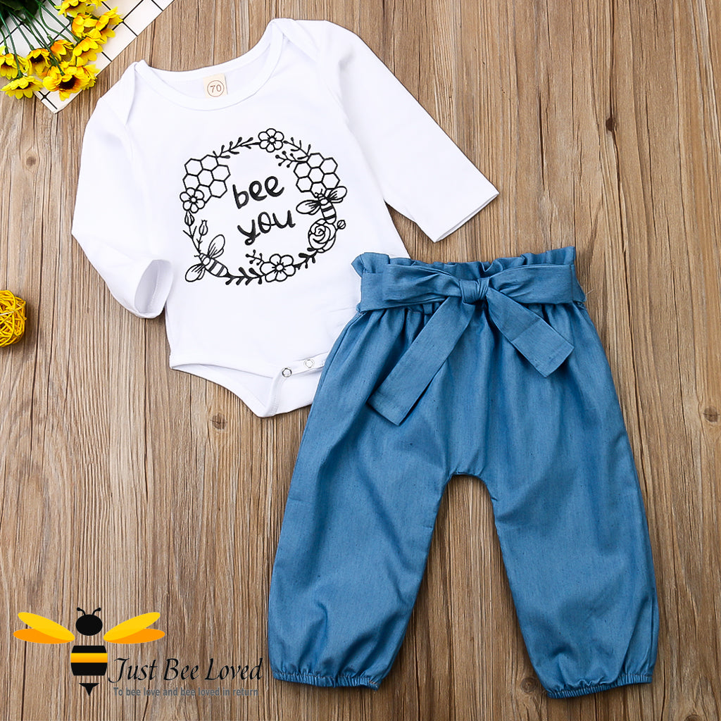 2-piece set featuring a white bodysuit with bees and flowers and the message "bee you" matched with coordinating harem styled blue pants.  