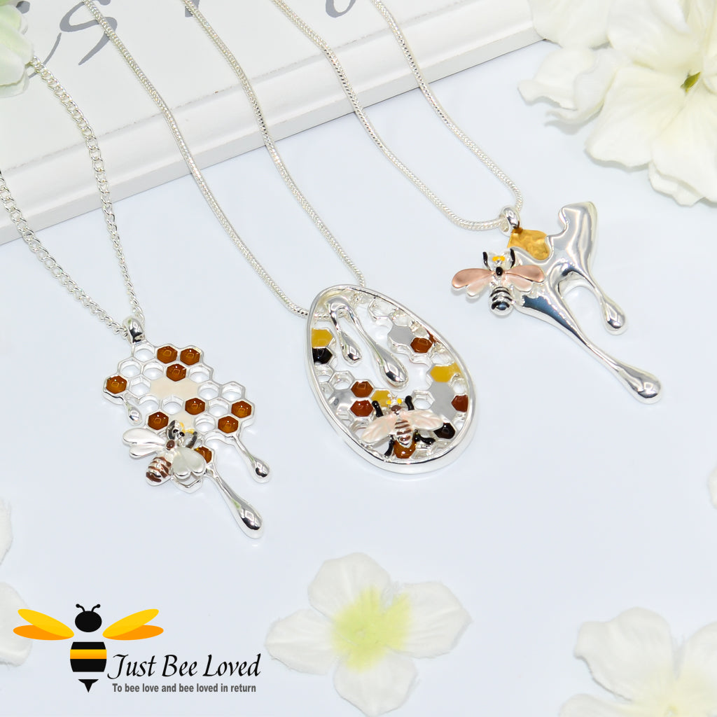 Metallic silver pendant necklaces designed to resemble honey drips and pollen with a honey bee motif