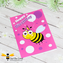Load image into Gallery viewer, image of a pink bee themed birthday card featuring a cartoon illustrations of a young bee wearing a party hat with white and purple balloons.
