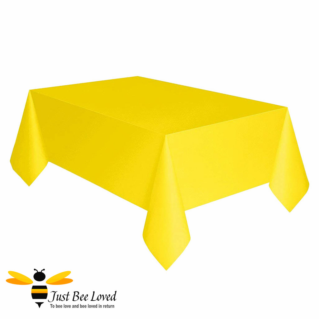 A sunshine yellow reusable plastic table cover displayed on a table.